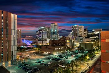 a cityscape at night with a colorful sky